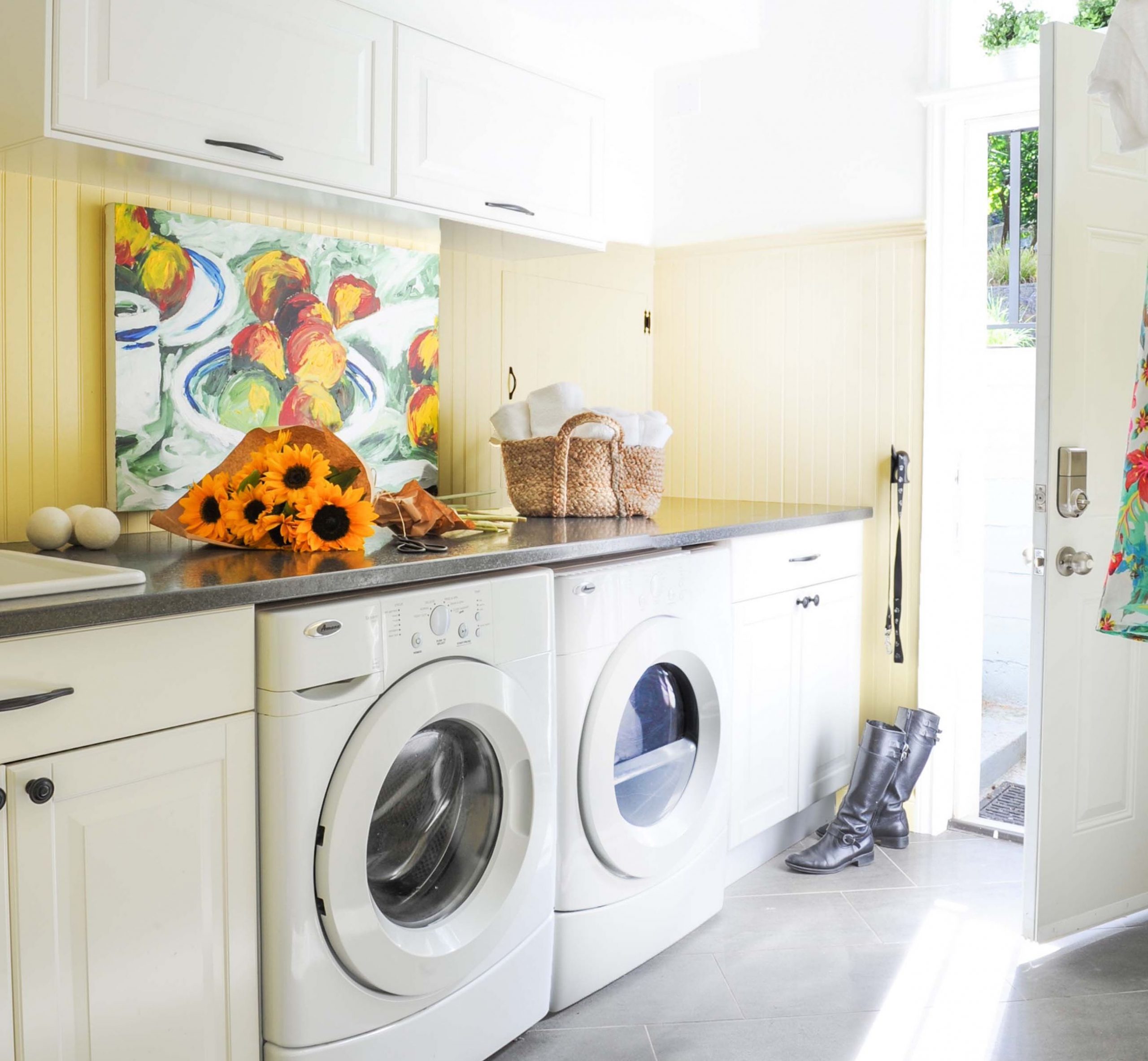 decluttering laundry room fresh bright sunny light ywllow white cabinets colourful art