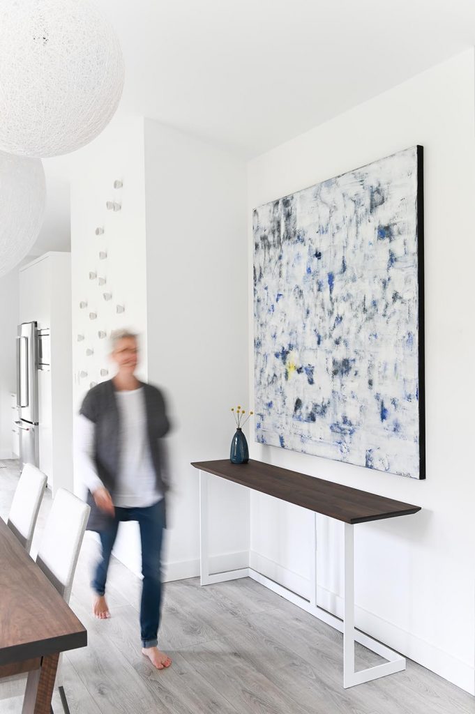 interior-design-home-furnishings-west-vancouver-incorporating-artwork-into-your-home-designer-walking-through-home-by-large-painting-custom