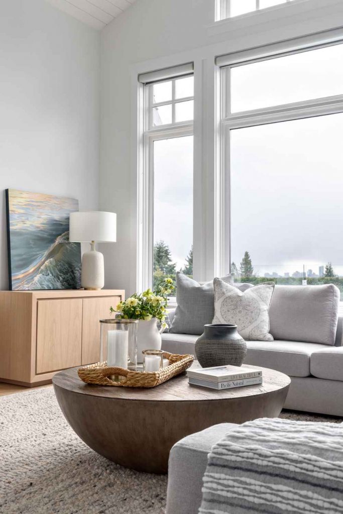 simply-home-decorating-deep-cove-finishing-touches-on-a-home-living-room-with-soft-muted-colours-large-window-natural-light-round-coffee-table-fresh-interior-design