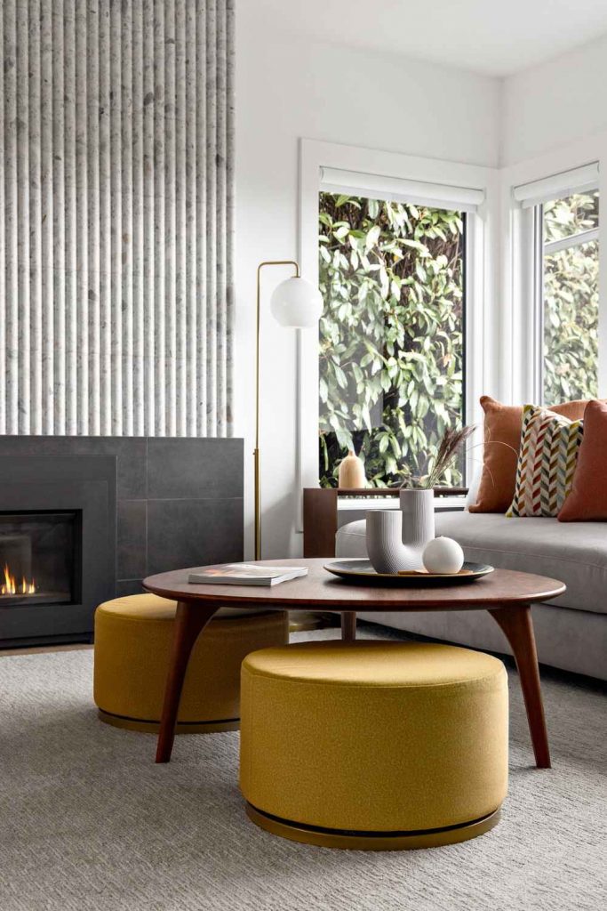 simply-home-decorating-north-vancouver-finishing-touches-on-a-home-contemporary-living-room-upholstered-seating-around-curved-coffee-table-fireplace-detail-modern-furnishings