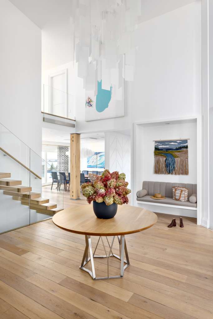 prince edward island bright expansive entryway white oak flooring custom bench local woven artwork round pedestal table canadian interior design studio simply home decorating