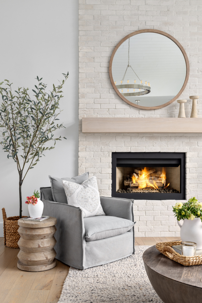 simply-home-decorating-vancouver-interior-design-furnishing-gray-accent-chair-modern-home-brick-fireplace-light-wood