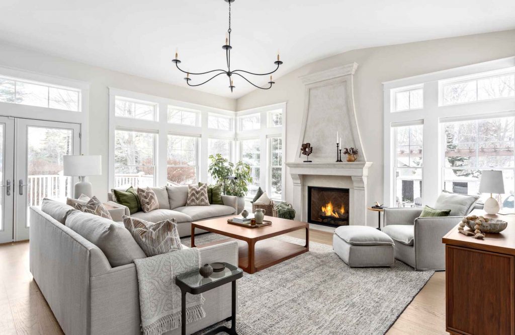simply-home-decorating-north-vancouver-bc-interior-design-investment-living-room-with-custom-gray-sofas-fireplace-large-windows-contemporary-home-furnishings