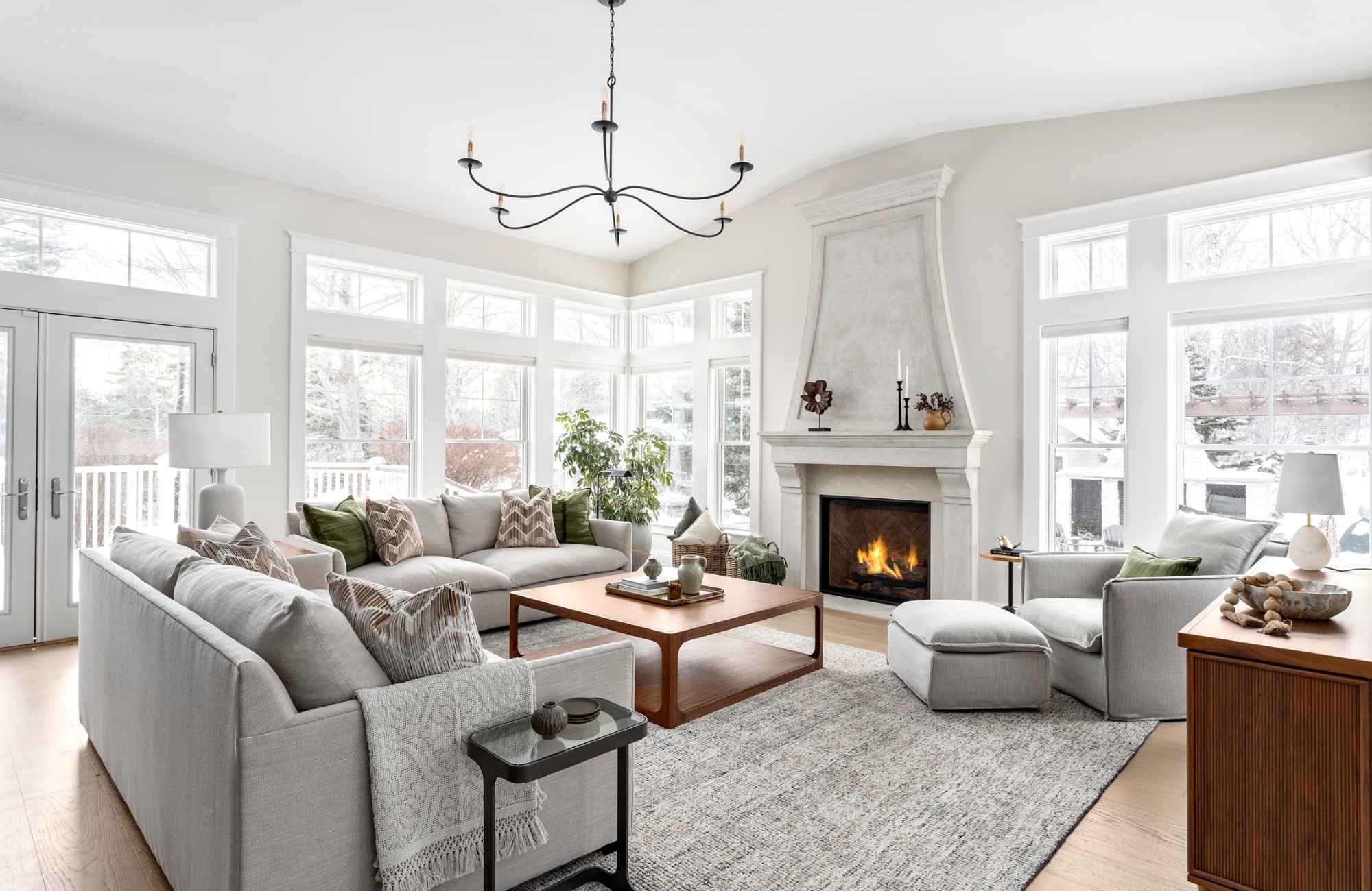 simply-home-decorating-north-vancouver-bc-interior-design-investment-living-room-with-custom-gray-sofas-fireplace-large-windows-contemporary-home-furnishings